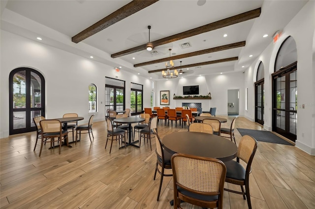 dining space featuring french doors, a notable chandelier, and beamed ceiling