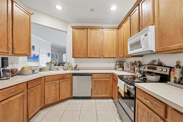 kitchen featuring light tile patterned floors, stainless steel appliances, crown molding, and sink