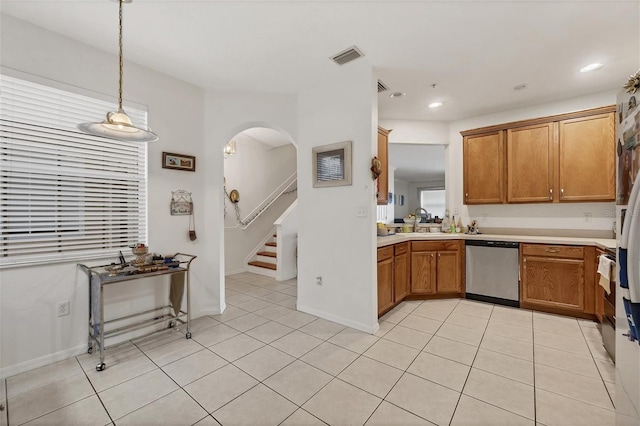 kitchen with stainless steel dishwasher, light tile patterned floors, sink, and pendant lighting