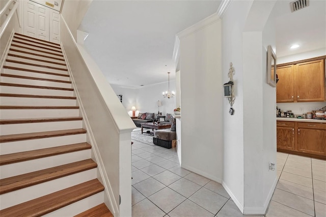 stairway with crown molding, tile patterned floors, and a notable chandelier