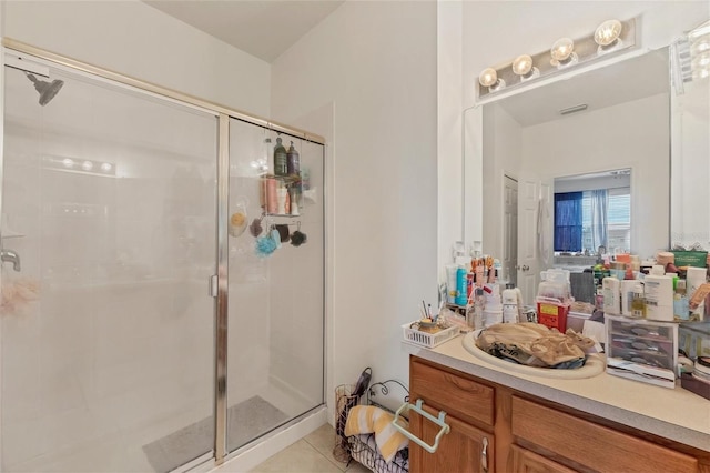 bathroom featuring tile patterned flooring, a shower with shower door, and vanity