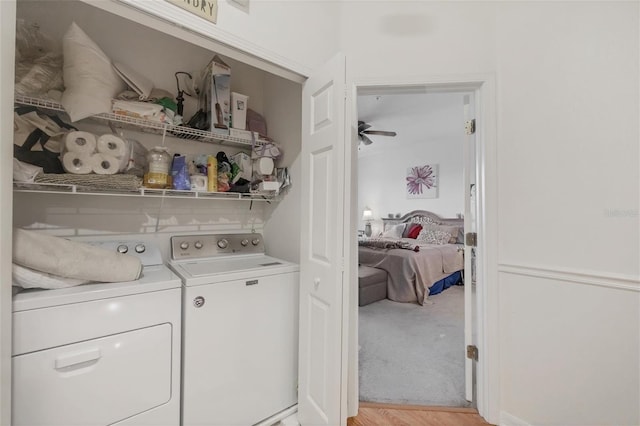 clothes washing area with ceiling fan, light hardwood / wood-style floors, and washer and clothes dryer