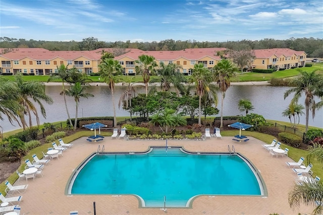 view of pool featuring a water view and a patio