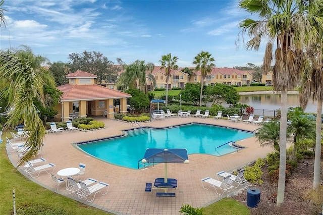 view of pool with a water view and a patio