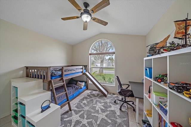 bedroom featuring ceiling fan, a textured ceiling, light tile patterned floors, and lofted ceiling