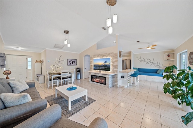 living room featuring vaulted ceiling, crown molding, and light tile patterned floors