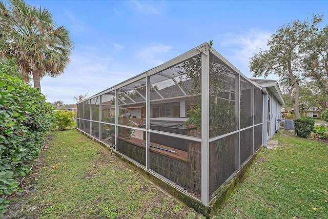 exterior space with glass enclosure and a yard