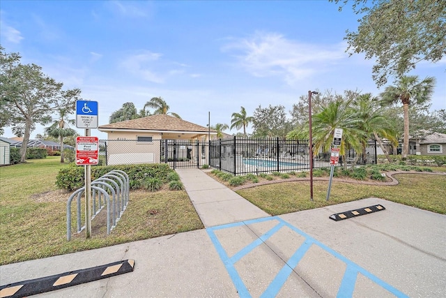 view of home's community with a swimming pool and a lawn