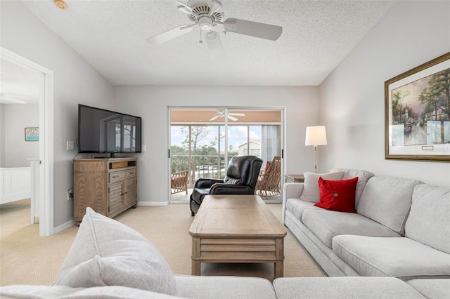 living room with ceiling fan, light colored carpet, and a textured ceiling