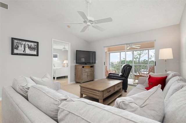 carpeted living room featuring ceiling fan, a textured ceiling, and lofted ceiling