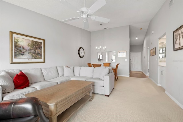 carpeted living room with ceiling fan with notable chandelier