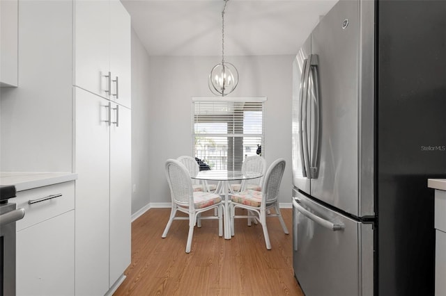 dining area featuring light hardwood / wood-style flooring and an inviting chandelier