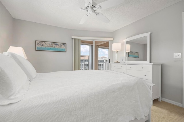 bedroom featuring ceiling fan, access to exterior, light colored carpet, and a textured ceiling