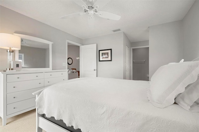 carpeted bedroom with a textured ceiling and ceiling fan