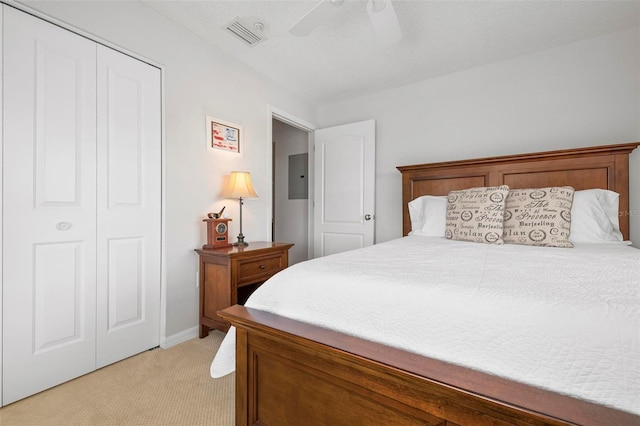 carpeted bedroom featuring ceiling fan, electric panel, and a closet