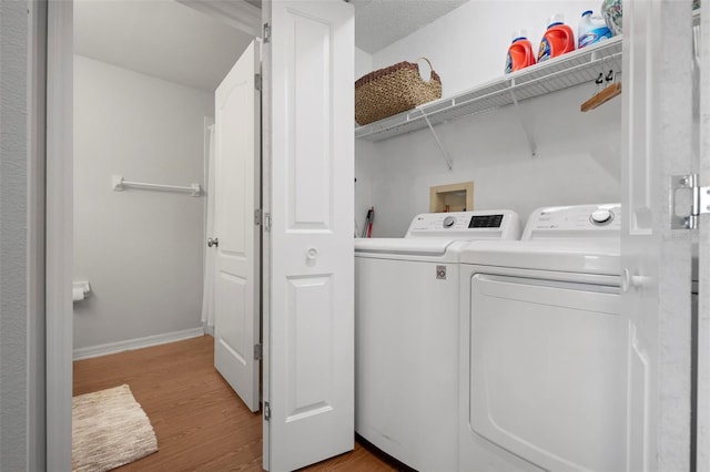 clothes washing area featuring light wood-type flooring and independent washer and dryer