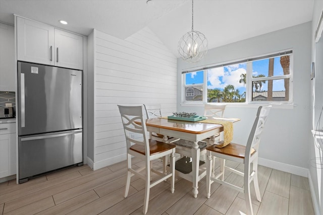 dining area featuring an inviting chandelier and lofted ceiling