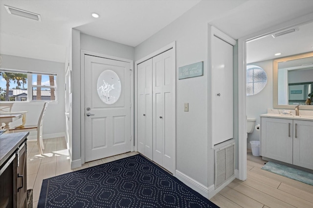 entryway with sink and light hardwood / wood-style floors