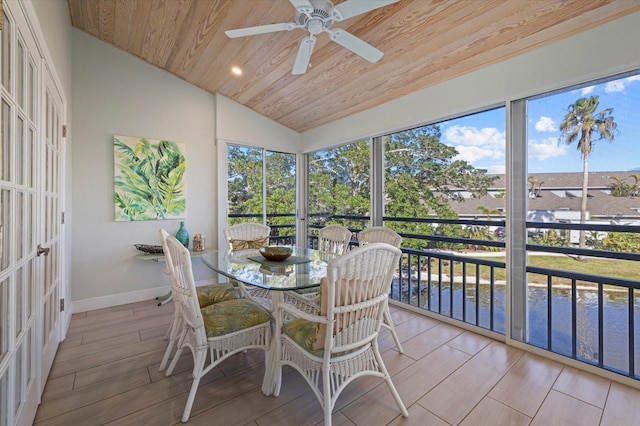 sunroom with wood ceiling, vaulted ceiling, a water view, and ceiling fan