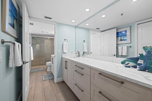 bathroom featuring toilet, walk in shower, and vanity