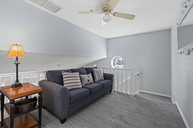 living room featuring ceiling fan and dark colored carpet