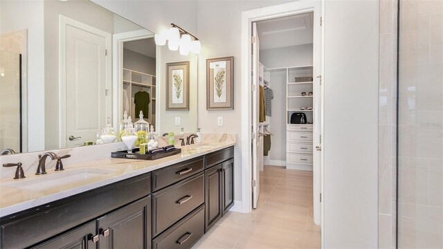 bathroom featuring a shower with shower door, vanity, and tile patterned flooring