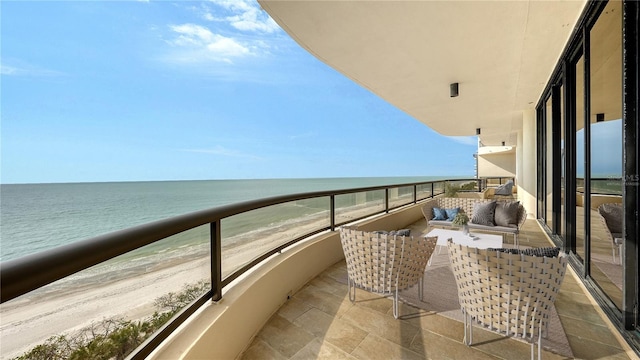 balcony with a water view and a view of the beach