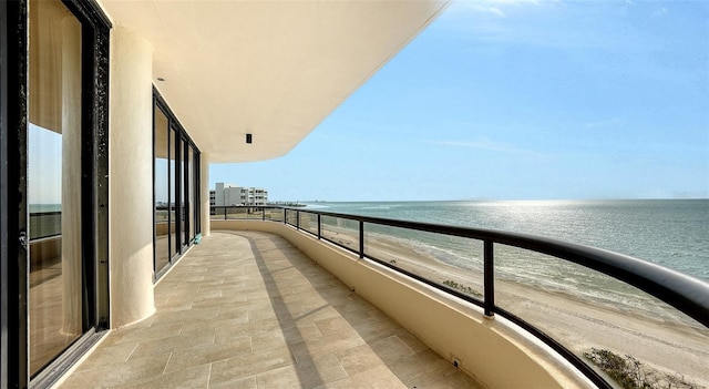 balcony featuring a water view and a beach view