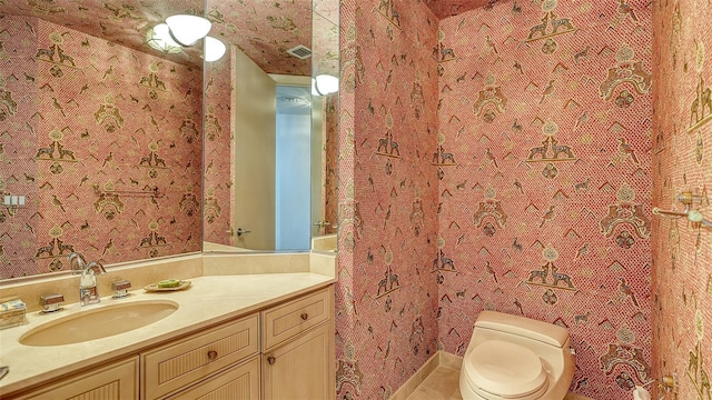 bathroom featuring toilet, tile patterned flooring, and vanity