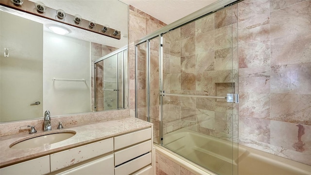 bathroom featuring combined bath / shower with glass door and vanity