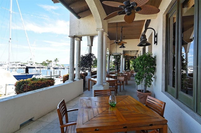 view of patio / terrace with a balcony, ceiling fan, and a water view