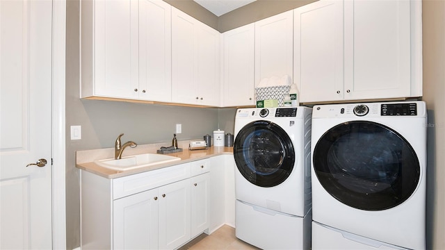 laundry area featuring cabinets, sink, washer and clothes dryer, and light tile patterned floors