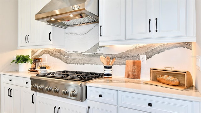 kitchen with range hood, stainless steel gas cooktop, white cabinets, and tasteful backsplash