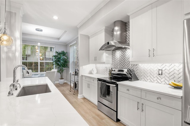 kitchen featuring wall chimney range hood, white cabinetry, sink, and electric stove