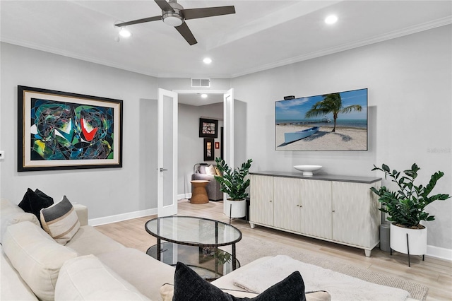 living room featuring crown molding, light hardwood / wood-style floors, and ceiling fan