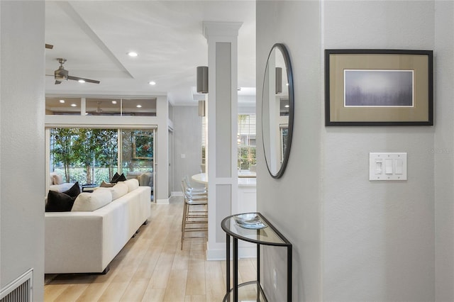 interior space featuring decorative columns, ceiling fan, and light wood-type flooring