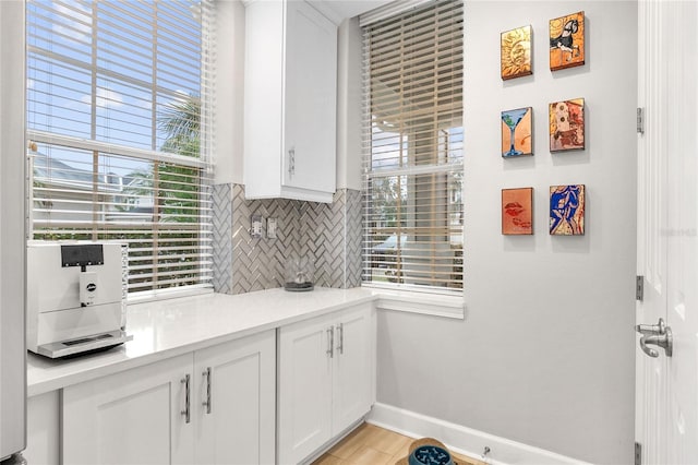 kitchen with light hardwood / wood-style floors, white cabinetry, and decorative backsplash