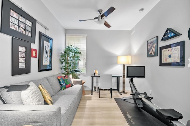 exercise area featuring ceiling fan and light wood-type flooring