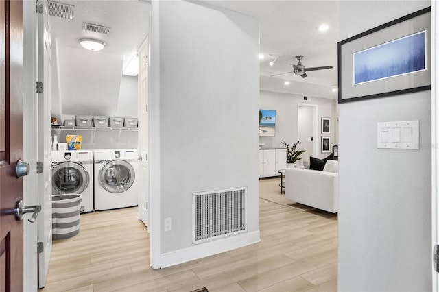 clothes washing area featuring ceiling fan, light hardwood / wood-style floors, and independent washer and dryer