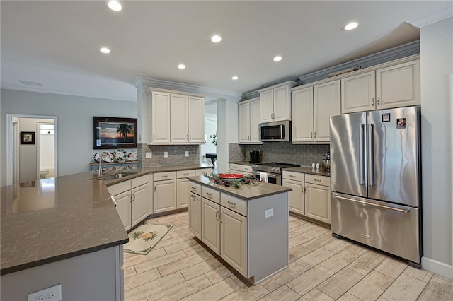 kitchen with stainless steel appliances, white cabinets, a center island, and sink