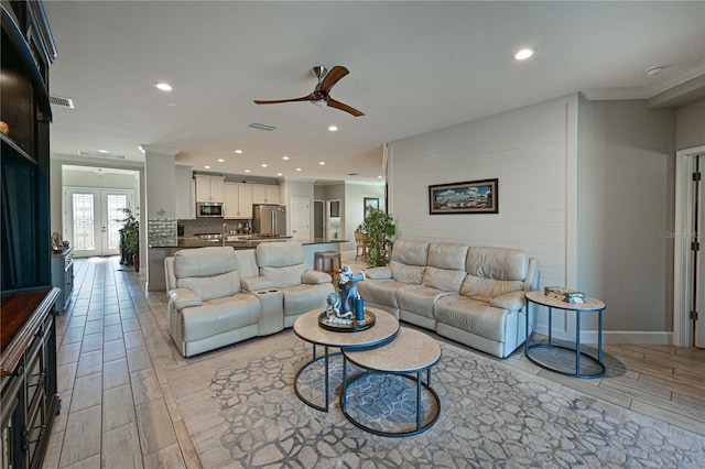 living room featuring ceiling fan, french doors, and ornamental molding