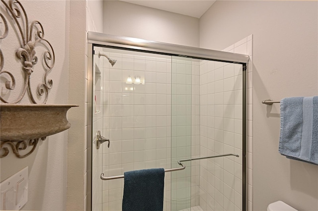 bathroom with toilet and an enclosed shower