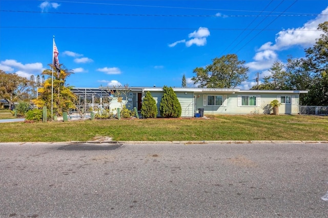 ranch-style home with a front yard and glass enclosure