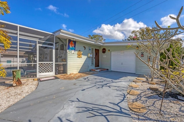 view of front of home featuring a garage and glass enclosure