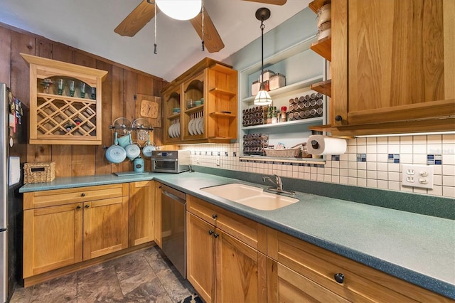 kitchen featuring wooden walls, sink, backsplash, hanging light fixtures, and stainless steel dishwasher