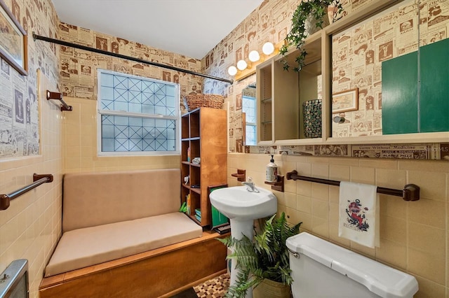 bathroom featuring tile walls, toilet, and walk in shower