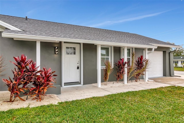 entrance to property with a garage and a yard