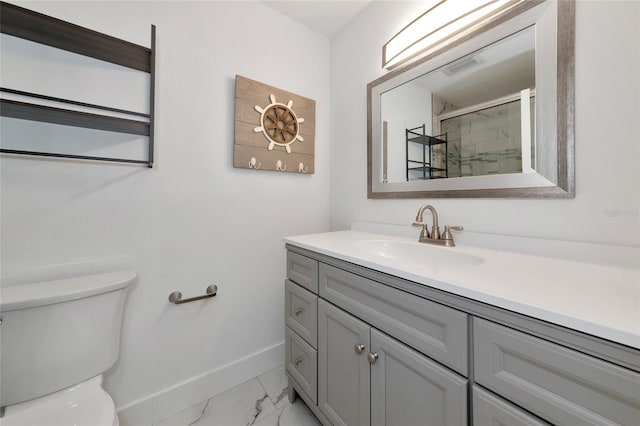 bathroom with vanity, a shower with shower door, and toilet