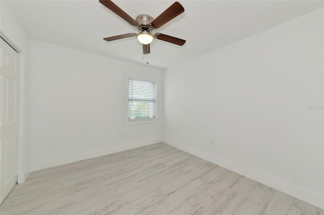 empty room with ceiling fan and light hardwood / wood-style floors