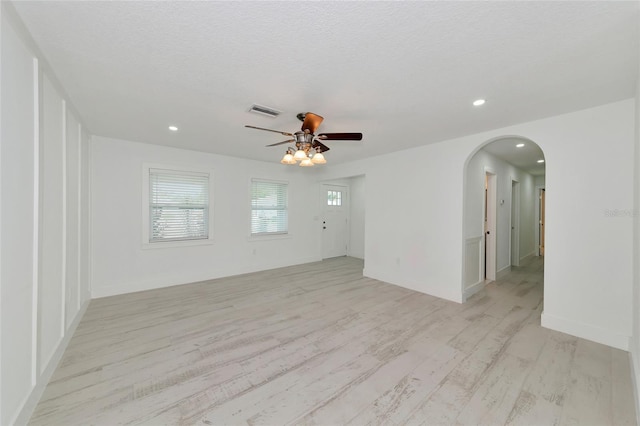 unfurnished room featuring ceiling fan, light hardwood / wood-style flooring, and a textured ceiling